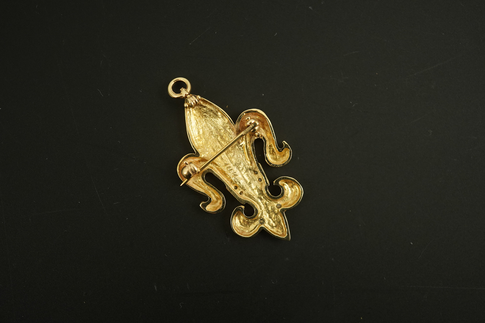 A modern 14k gold and diamond chip cluster set fleur de lys pendant